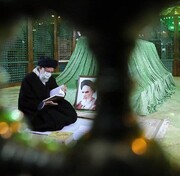 عکسی از قرآن خواندن رهبر انقلاب بر سر مزار امام خمینی(ره)