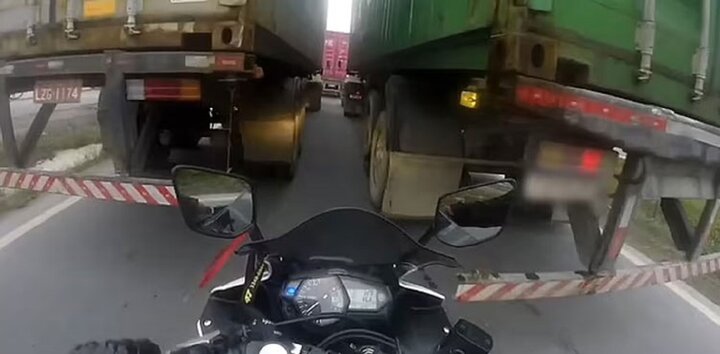 فرار معجزه‌آسای موتورسوار از مرگ حین عبور از میان دو کامیون / فیلم
