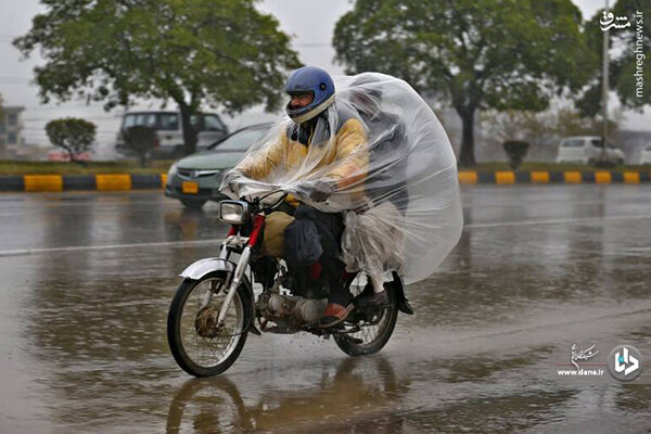 ابتکار عجیب و جالب موتور سوار پاکستانی در روز بارانی / عکس