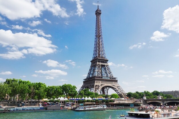 Eiffel tour over seine river waters at summer day, paris, france