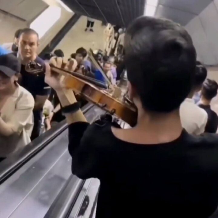 نوازندگی یک جوان با ویولن در مترو تهران + عکس