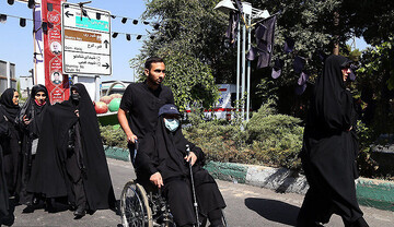 قدم زدن یک زن جوان با وجود قطع نخاع مقابل حرم امام حسین با کمک دستگاه ایرانی + فیلم